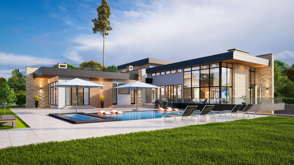 A villa with a glass facade and a swimming pool in the evening sun.