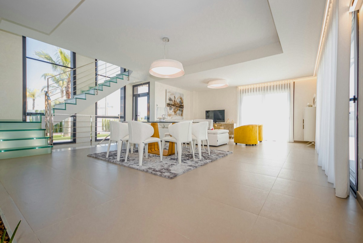 A spacious living floor with a staircase and a view of the garden.